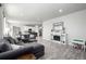 Open-concept living room with a gray sofa, fireplace, flowing into a kitchen and dining area at 9334 Sedalia St, Commerce City, CO 80022
