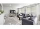 Inviting living room features a gray sectional, decorative console, and large windows for natural light at 9334 Sedalia St, Commerce City, CO 80022