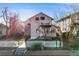 Inviting home with a cozy balcony, red awnings, a well-kept lawn, and a charming white picket fence at 2047 S Franklin St, Denver, CO 80210