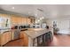 Kitchen with granite island with bar stool seating, light wood cabinets and hardwood floors at 2047 S Franklin St, Denver, CO 80210