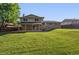 A spacious backyard, with lush green grass, leads to a brick house with a covered patio at 2931 S Sidney Ct, Denver, CO 80231