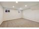 Spacious basement area with carpeted floors and ample lighting from recessed fixtures and two windows at 2931 S Sidney Ct, Denver, CO 80231