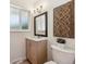 Bright bathroom featuring a modern vanity, decorative wall art, and frosted glass window for natural light and privacy at 2931 S Sidney Ct, Denver, CO 80231