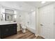 Modern bathroom boasting a dark vanity, stylish fixtures, and a tiled shower, blending functionality with sleek design at 2931 S Sidney Ct, Denver, CO 80231