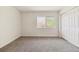 Carpeted bedroom with a closet and window, offering a simple and functional living space at 2931 S Sidney Ct, Denver, CO 80231