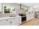 Bright and modern kitchen featuring white cabinets, stainless steel appliances, and neutral backsplash at 2931 S Sidney Ct, Denver, CO 80231