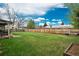 Expansive fenced backyard featuring a lush green lawn and a covered patio area, perfect for outdoor living at 8151 S Marshall Ct, Littleton, CO 80128