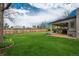 Well-maintained backyard featuring a lush lawn, mature trees, and a covered patio with a privacy fence at 8151 S Marshall Ct, Littleton, CO 80128