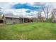 Spacious backyard with a covered patio, lush lawn, and privacy fence offering a great space for outdoor activities at 8151 S Marshall Ct, Littleton, CO 80128