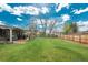 Large, well-maintained backyard with a wooden fence, covered patio, and mature trees, ideal for relaxation and entertaining at 8151 S Marshall Ct, Littleton, CO 80128