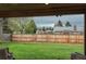 View of the fenced backyard with a landscaped lawn and neighboring houses at 8151 S Marshall Ct, Littleton, CO 80128