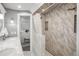 Elegant bathroom with marble tile shower and glass door, plus views into main bedroom at 8151 S Marshall Ct, Littleton, CO 80128