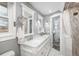 Bathroom featuring double vanity sinks, framed mirrors, and a shower with marble tile at 8151 S Marshall Ct, Littleton, CO 80128