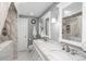Modern bathroom with marble double vanity, framed mirrors, and a separate marble shower at 8151 S Marshall Ct, Littleton, CO 80128
