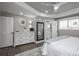 Spacious bedroom featuring a tray ceiling, ensuite bathroom, and light gray walls at 8151 S Marshall Ct, Littleton, CO 80128