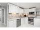 Bright kitchen featuring white cabinetry, stainless steel appliances, mosaic tile backsplash and granite countertops at 8151 S Marshall Ct, Littleton, CO 80128