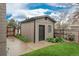 Exterior view of a well-maintained shed with vertical siding, landscaping, and a secure door in a backyard setting at 8151 S Marshall Ct, Littleton, CO 80128