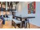 Dining area with a large table and bench, and a view of the kitchen and loft in the background at 1000 E 18Th Ave # 107, Denver, CO 80218