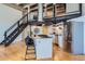 Spacious kitchen with island, seating, and stainless steel appliances, stairs to loft at 1000 E 18Th Ave # 107, Denver, CO 80218