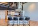 Bright kitchen with stainless appliances, island seating, and industrial design elements at 1000 E 18Th Ave # 107, Denver, CO 80218