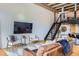 Open-concept living area with modern design, hardwood floors, metal stairs and exposed ceiling at 1000 E 18Th Ave # 107, Denver, CO 80218
