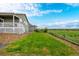 Landscaped backyard with a green lawn and split rail fence at 42425 Forest Oaks Dr, Elizabeth, CO 80107