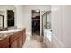 Well-lit bathroom featuring granite counters, tile floors, and a glass-enclosed shower near a walk-in closet at 42425 Forest Oaks Dr, Elizabeth, CO 80107