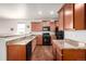 Bright kitchen with wooden cabinets, granite countertops, and modern appliances creates a functional cooking space at 42425 Forest Oaks Dr, Elizabeth, CO 80107