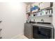 Modern laundry room with newer washer and dryer and upper shelving at 42425 Forest Oaks Dr, Elizabeth, CO 80107