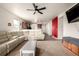 Open concept living room with white sectional, ceiling fan and view of the kitchen at 42425 Forest Oaks Dr, Elizabeth, CO 80107