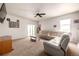 Bright living room with white sectional, ceiling fan, neutral carpet, and sliding glass door to the backyard at 42425 Forest Oaks Dr, Elizabeth, CO 80107