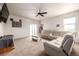 Living room with ceiling fan, light beige carpet, and sliding glass door to the backyard at 42425 Forest Oaks Dr, Elizabeth, CO 80107
