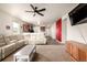Open concept living room with white sectional, ceiling fan and view of the kitchen at 42425 Forest Oaks Dr, Elizabeth, CO 80107