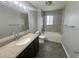 Well-lit bathroom with a vanity, granite countertop, tiled shower and updated fixtures at 1592 S Memphis St, Aurora, CO 80017