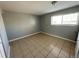 This bedroom has neutral-colored tile flooring, gray walls, and a window for natural light at 1592 S Memphis St, Aurora, CO 80017