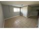 This bedroom has neutral-colored tile flooring, gray walls, and a window for natural light at 1592 S Memphis St, Aurora, CO 80017