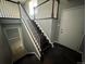 Well-lit staircase with a white railing contrasts dark wood steps, adding character to this home's interior at 1592 S Memphis St, Aurora, CO 80017