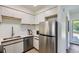 Bright kitchen features stainless steel appliances, white cabinetry with stylish hardware, and ample counter space at 2120 W 31St Ave, Denver, CO 80211