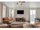 Bright living room with neutral tones, large windows, a ceiling fan, and sliding glass doors to the balcony at 8811 Meade St, Westminster, CO 80031