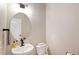 Cozy powder room with an oval mirror, sink, toilet, and neutral wall paint at 8811 Meade St, Westminster, CO 80031