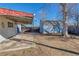 View of a backyard with a patio cover that connects to the blue shed with an aged door at 5366 S Elmwood St, Littleton, CO 80120