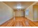 Spacious living room features a large window, hardwood flooring, and modern lighting fixture at 5366 S Elmwood St, Littleton, CO 80120