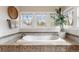Relaxing bathroom featuring a soaking tub, large windows, and a stylish plant, perfect for unwinding at 2486 S Monroe St, Denver, CO 80210