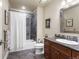 Bathroom with tiled shower and tub, dark wood vanity, granite counters and tiled floor at 2486 S Monroe St, Denver, CO 80210