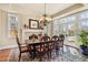 Bright dining room with a fireplace, chandelier, hardwood floors, and French doors leading outside at 2486 S Monroe St, Denver, CO 80210