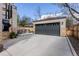 Spacious two-car garage with stone accents and ample parking on a well-maintained concrete driveway at 2486 S Monroe St, Denver, CO 80210