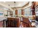 A chef's kitchen has a connected living room, a large island, modern lighting, and stainless steel appliances at 2486 S Monroe St, Denver, CO 80210