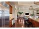 A modern kitchen leads to a living room, featuring an island with seating, granite counters, and stainless appliances at 2486 S Monroe St, Denver, CO 80210