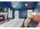 Bright main bedroom with a stone fireplace, plush bedding, and a view to the outdoor deck and yard at 2486 S Monroe St, Denver, CO 80210