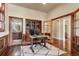 Spacious home office with hardwood floors, built-in shelving, and access to an adjacent bathroom at 2486 S Monroe St, Denver, CO 80210